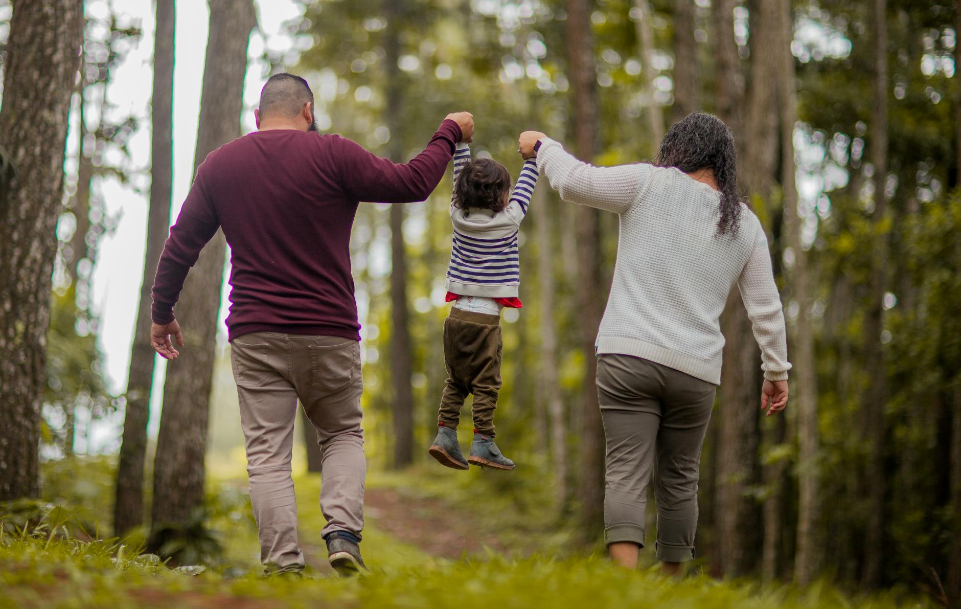 man and woman carrying toddler