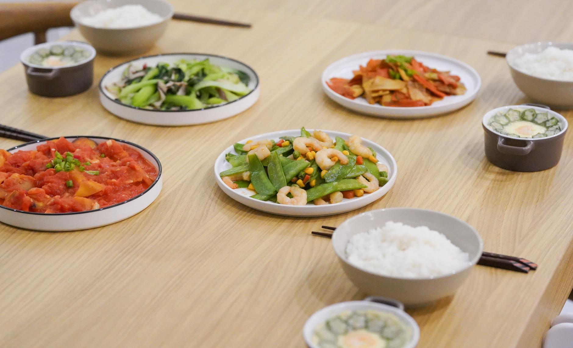 three bowls of rice and four vegetable meals on the table