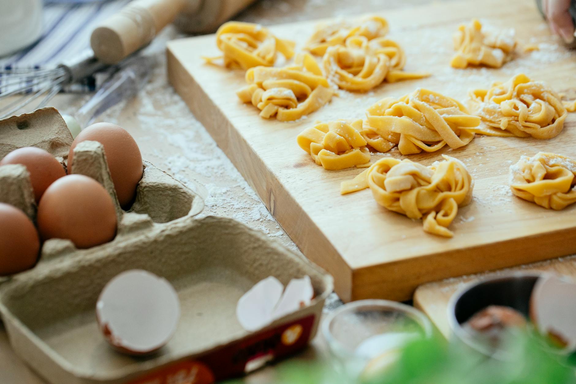 raw tagliatelle nests on wooden board